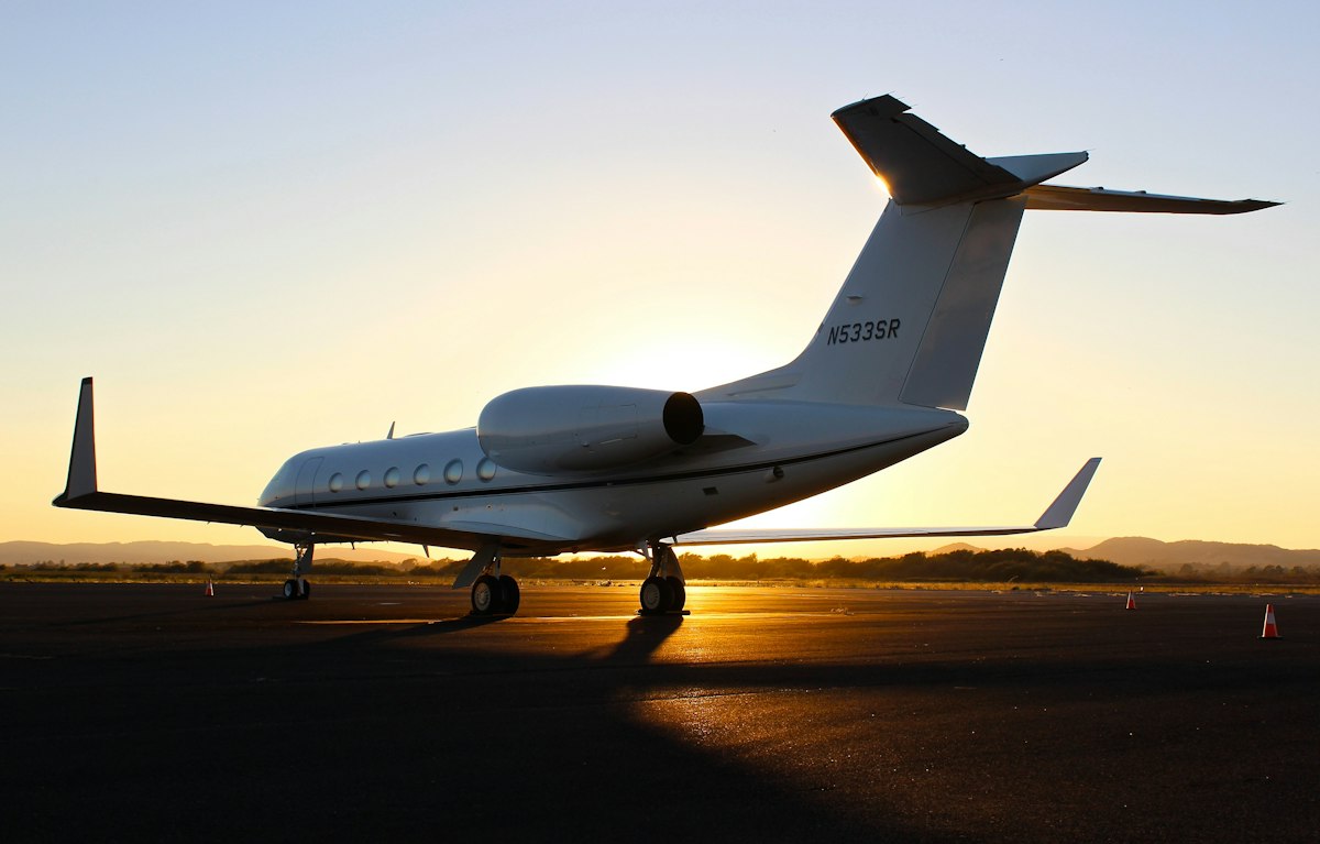 A business jet parked on a ramp at sunset